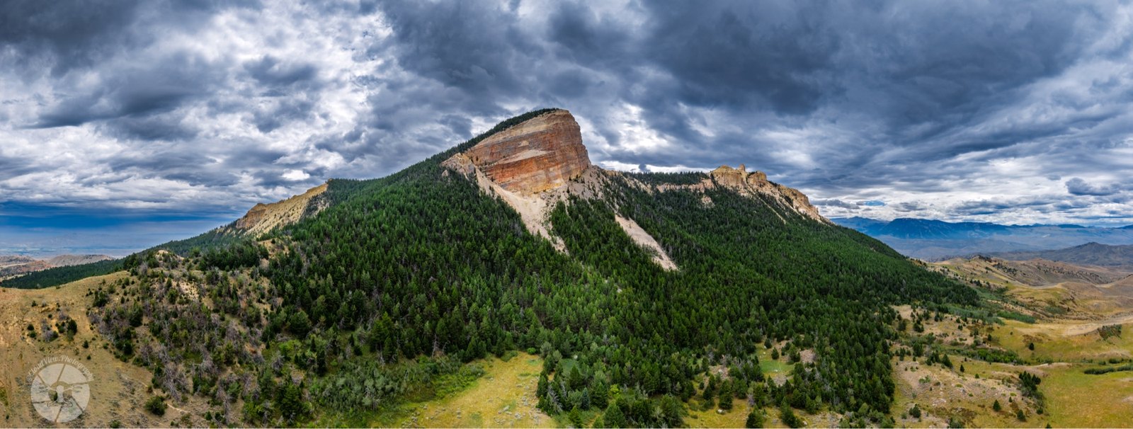 Heart Mountain in Wyoming, layered rock face beneath a stormy sky.